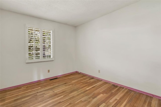 10014 Aldred Dr, Sunset Hills, MO 63128 - spare room with light wood-style floors, a textured ceiling, and baseboards