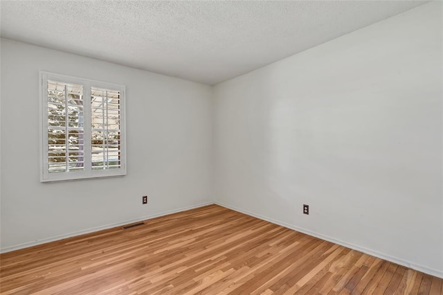 10014 Aldred Dr, Sunset Hills, MO 63128 - unfurnished room with light wood-style flooring, baseboards, and a textured ceiling