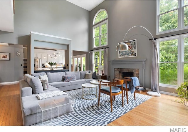 1619 Highland Valley Cir, Wildwood, MO 63005 - living room with a high ceiling, wood finished floors, and a brick fireplace