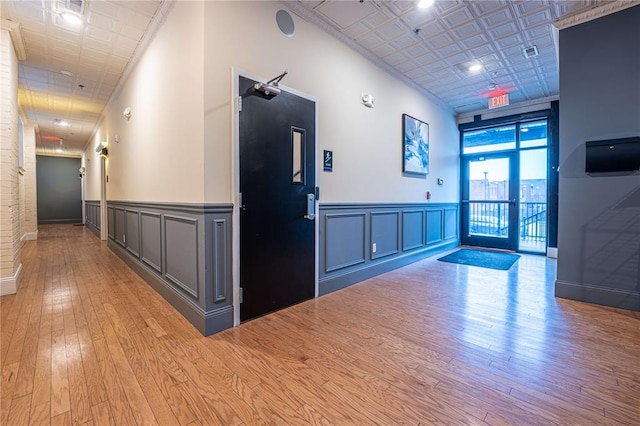 building lobby with wainscoting, a decorative wall, and ornamental molding