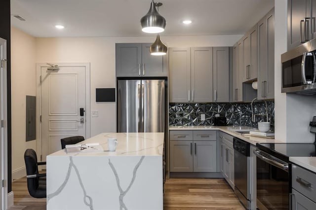 kitchen with stainless steel appliances, gray cabinets, electric panel, backsplash, and recessed lighting