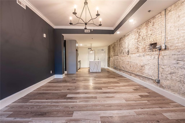 spare room with a chandelier, wood finished floors, crown molding, baseboards, and recessed lighting