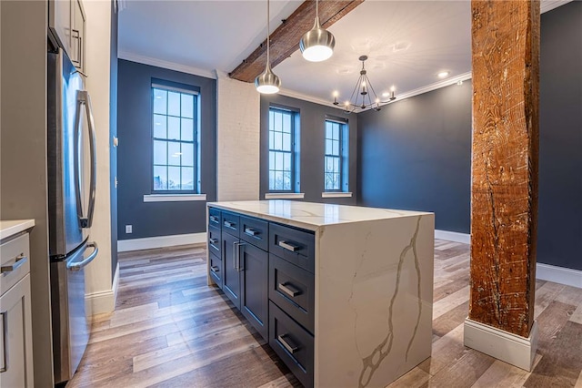 kitchen with ornamental molding, light wood-style floors, a chandelier, freestanding refrigerator, and baseboards