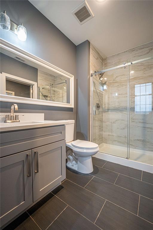 full bath with toilet, a shower stall, and vanity