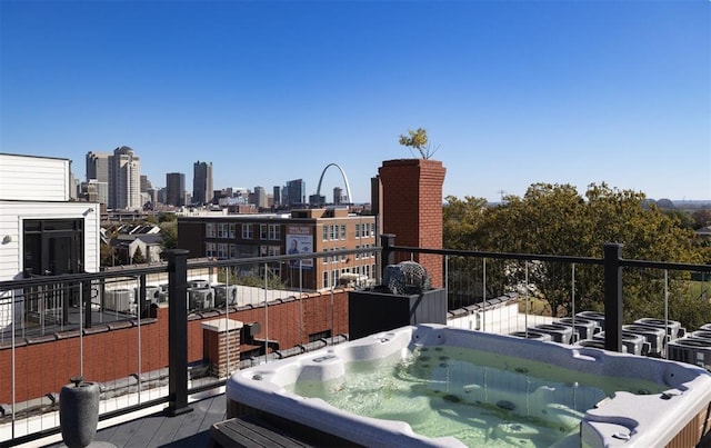 balcony with a hot tub and a view of skyline