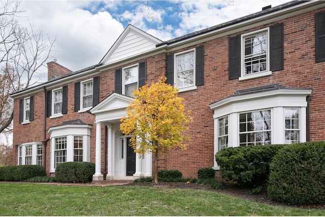 15 Briarcliff Rd, Ladue, MO 63124 - georgian-style home with brick siding, a front yard, and a chimney