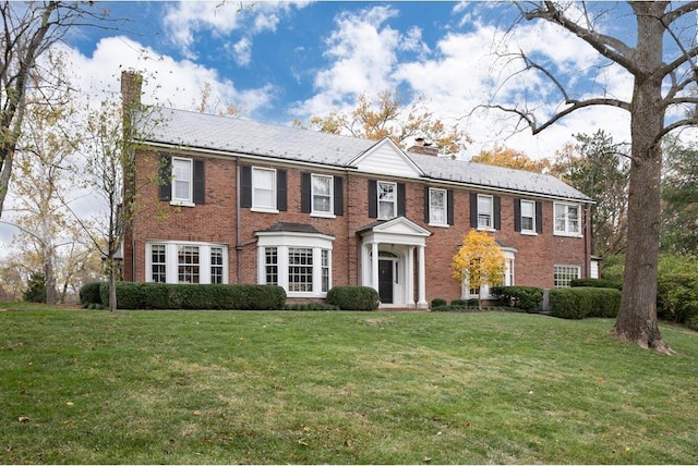 15 Briarcliff Rd, Ladue, MO 63124 - view of front of property featuring a chimney, a front lawn, and brick siding