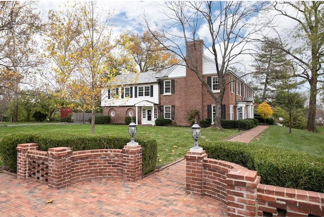 15 Briarcliff Rd, Ladue, MO 63124 - view of front of home featuring a front yard, a chimney, and brick siding