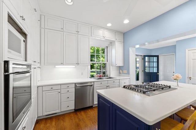 15 Briarcliff Rd, Ladue, MO 63124 - kitchen with stainless steel appliances, a sink, white cabinetry, a kitchen bar, and recessed lighting