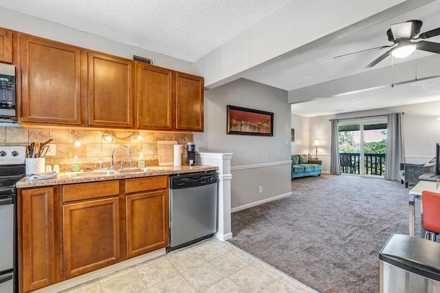 1843 Gascony Parc Dr Unit 1843, Lake St Louis, MO 63367 - kitchen featuring stainless steel appliances, a sink, light carpet, brown cabinets, and a textured ceiling
