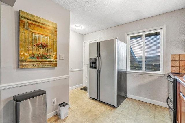 1843 Gascony Parc Dr Unit 1843, Lake St Louis, MO 63367 - kitchen featuring appliances with stainless steel finishes, a textured ceiling, baseboards, and a textured wall
