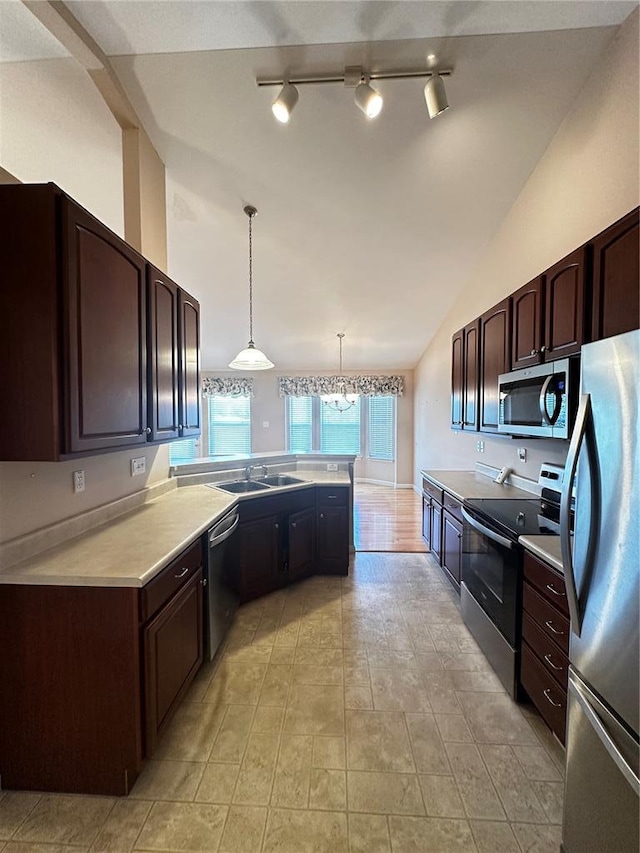 kitchen featuring appliances with stainless steel finishes, a sink, light countertops, lofted ceiling, and dark brown cabinetry