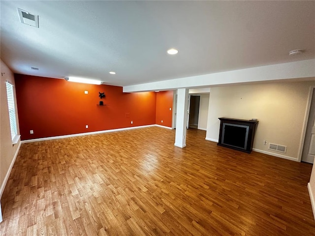 basement with wood finished floors, baseboards, a fireplace, and recessed lighting