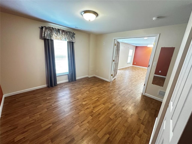 spare room featuring wood finished floors, baseboards, and a smoke detector