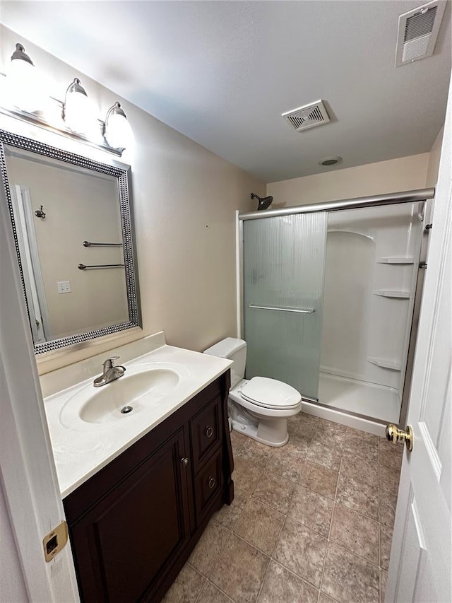 bathroom featuring a stall shower, vanity, and toilet