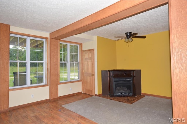 11370 County Road 5220, Rolla, MO 65401 - unfurnished living room with a textured ceiling, ceiling fan, wood finished floors, and a glass covered fireplace