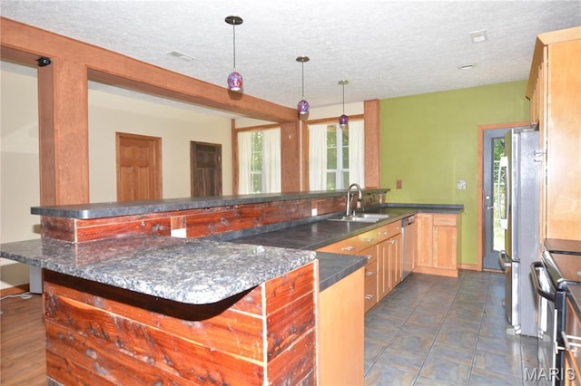 11370 County Road 5220, Rolla, MO 65401 - kitchen featuring a textured ceiling, stainless steel appliances, hanging light fixtures, light brown cabinets, and dark stone counters