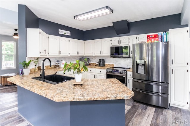 7011 Browns Ford Rd, Dittmer, MO 63023 - kitchen featuring appliances with stainless steel finishes, a peninsula, light countertops, white cabinetry, and tasteful backsplash