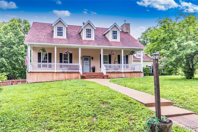 7011 Browns Ford Rd, Dittmer, MO 63023 - cape cod-style house with covered porch, a chimney, a front yard, and a shingled roof