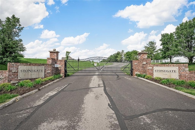 23 Stonegate Estates Dr, Hawk Point, MO 63349 - view of asphalt road featuring a gate, a gated entry, and curbs