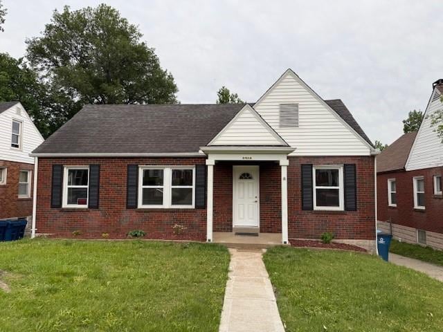 bungalow with brick siding and a front yard