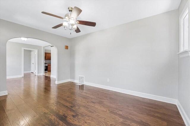8908 Apache Ln, Overland, MO 63114 - unfurnished room with arched walkways, ceiling fan, wood finished floors, and baseboards