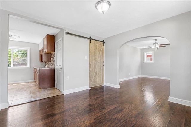 8908 Apache Ln, Overland, MO 63114 - spare room with a ceiling fan, plenty of natural light, arched walkways, and light wood-style floors