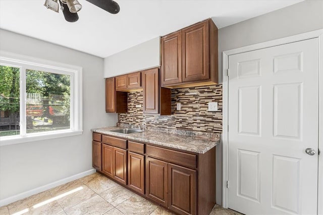 8908 Apache Ln, Overland, MO 63114 - kitchen with a sink, ceiling fan, tasteful backsplash, baseboards, and light countertops