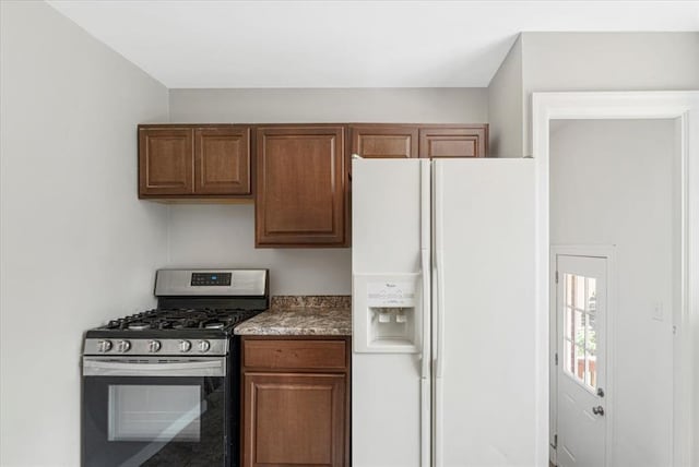 8908 Apache Ln, Overland, MO 63114 - kitchen with stainless steel gas range oven, white fridge with ice dispenser, and brown cabinets