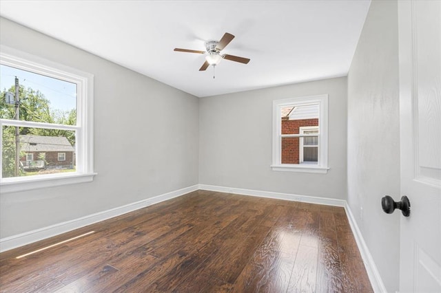 8908 Apache Ln, Overland, MO 63114 - empty room featuring plenty of natural light, dark wood finished floors, baseboards, and a ceiling fan