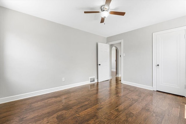 8908 Apache Ln, Overland, MO 63114 - unfurnished bedroom with wood finished floors, baseboards, arched walkways, and a ceiling fan