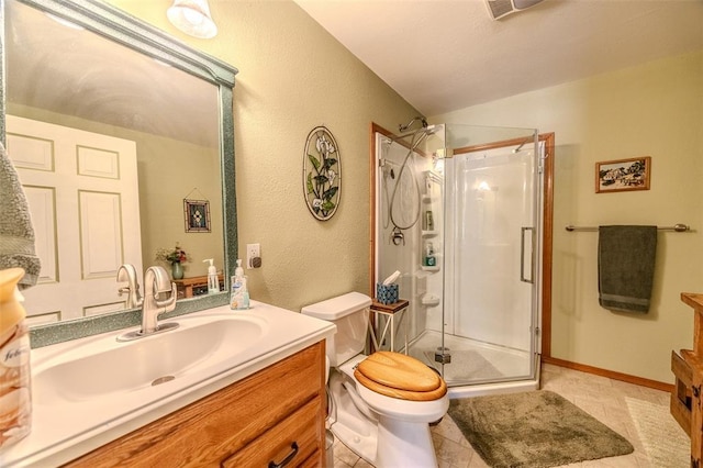 bathroom featuring vanity, a stall shower, toilet, a textured wall, and tile patterned flooring