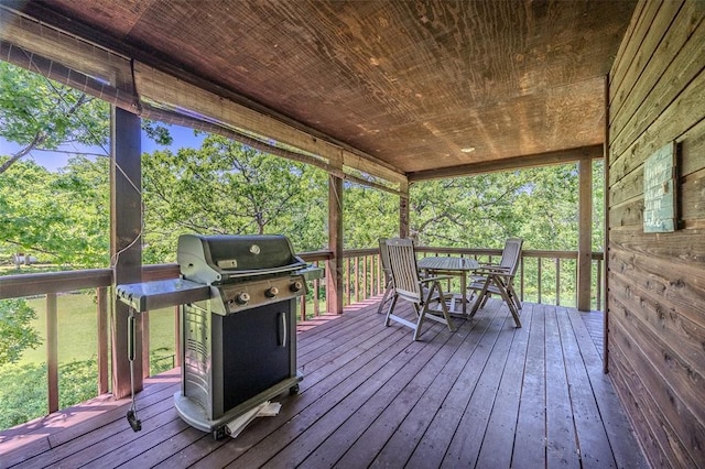 wooden deck with a grill and outdoor dining space
