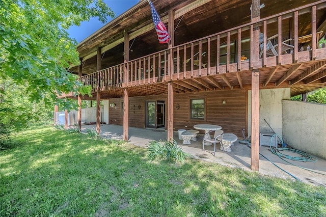 back of property featuring a lawn, a patio area, and a wooden deck