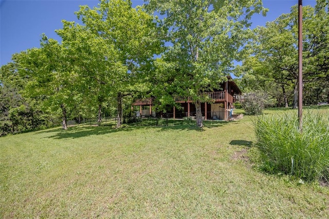 view of green lawn with a wooden deck