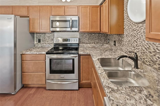1404 Hampton Ct, Belleville, IL 62223 - kitchen with stainless steel appliances, a sink, light wood-style flooring, decorative backsplash, and light stone counters