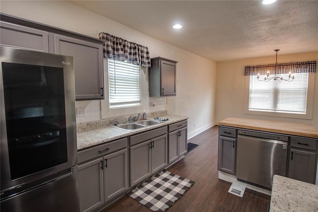 210 W Elm St, Alton, IL 62002 - kitchen featuring stainless steel appliances, a sink, gray cabinetry, dark wood-type flooring, and a chandelier