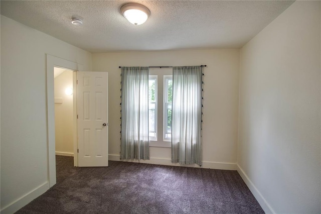 210 W Elm St, Alton, IL 62002 - unfurnished room with dark colored carpet, a textured ceiling, a smoke detector, and baseboards