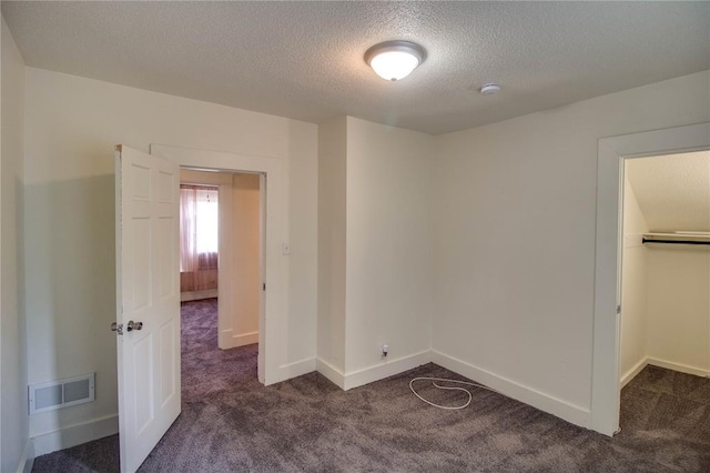 210 W Elm St, Alton, IL 62002 - unfurnished bedroom with carpet flooring, a textured ceiling, baseboards, and a closet