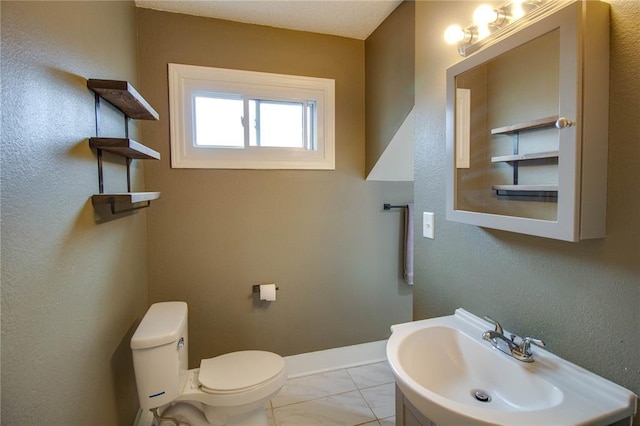 210 W Elm St, Alton, IL 62002 - bathroom with a sink, marble look tiles, toilet, and baseboards