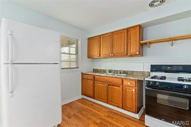 1321 Highmont Dr, Saint Louis, MO 63135 - kitchen with freestanding refrigerator, black gas range, brown cabinets, open shelves, and light wood-style flooring
