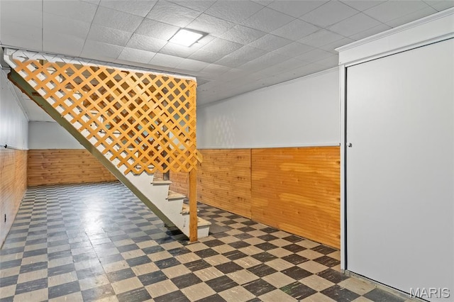 1321 Highmont Dr, Saint Louis, MO 63135 - below grade area with tile patterned floors, wooden walls, a wainscoted wall, and stairs