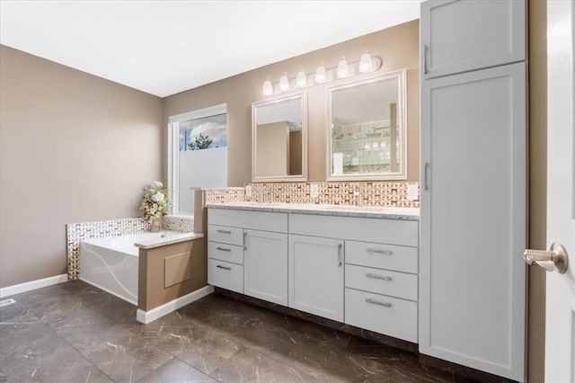 5 The Crossings Ct, Ofallon, MO 63366 - bathroom with marble look tiles, double vanity, a bath, baseboards, and tasteful backsplash