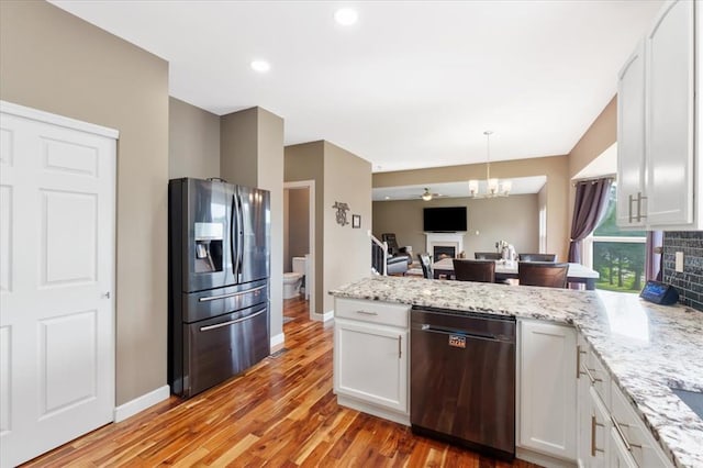 5 The Crossings Ct, Ofallon, MO 63366 - kitchen with stainless steel appliances, a fireplace, a peninsula, white cabinetry, and recessed lighting