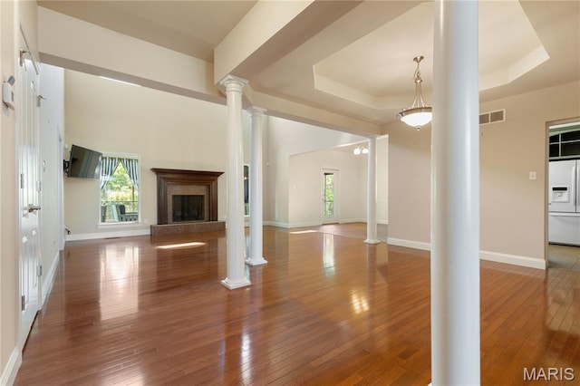 106 Tuscany Trace Dr, Saint Charles, MO 63303 - unfurnished living room with ornate columns, a tray ceiling, a high end fireplace, and plenty of natural light