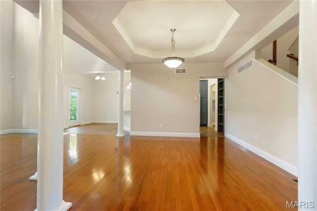 106 Tuscany Trace Dr, Saint Charles, MO 63303 - spare room with decorative columns, a raised ceiling, wood-type flooring, and baseboards