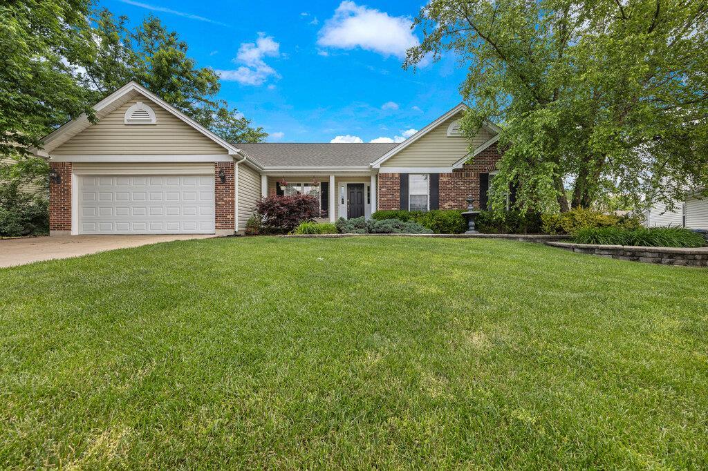 27 Palace Green Ct, Ofallon, MO 63366 - ranch-style house featuring an attached garage, brick siding, driveway, and a front lawn