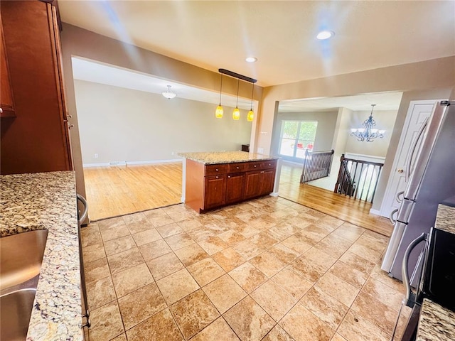 1202 S Mildred Ave, Salem, MO 65560 - kitchen featuring hanging light fixtures, baseboards, freestanding refrigerator, light stone countertops, and recessed lighting