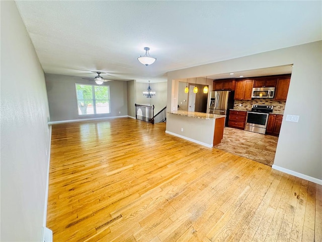 1202 S Mildred Ave, Salem, MO 65560 - unfurnished living room featuring light wood-style flooring, a chandelier, baseboards, and ceiling fan