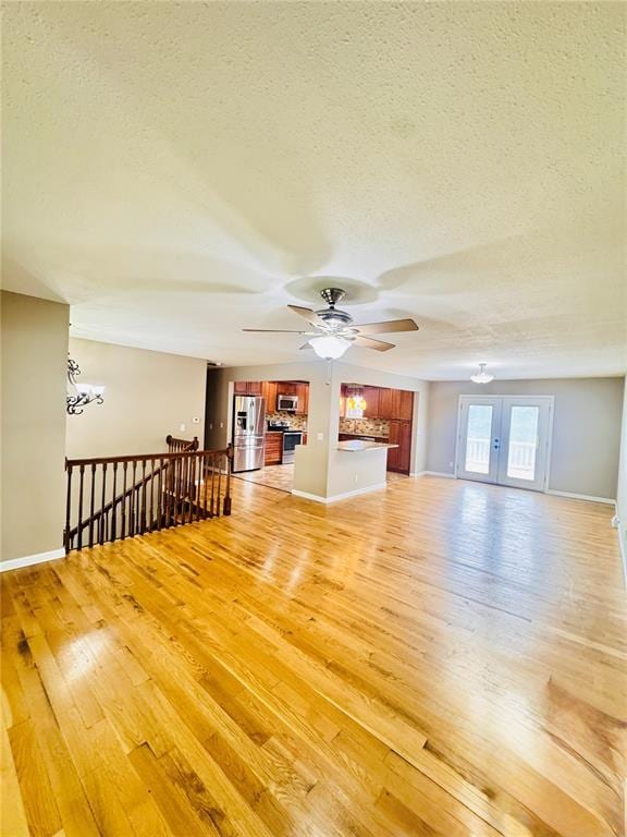 1202 S Mildred Ave, Salem, MO 65560 - unfurnished living room featuring a textured ceiling, light wood-style flooring, a ceiling fan, and baseboards